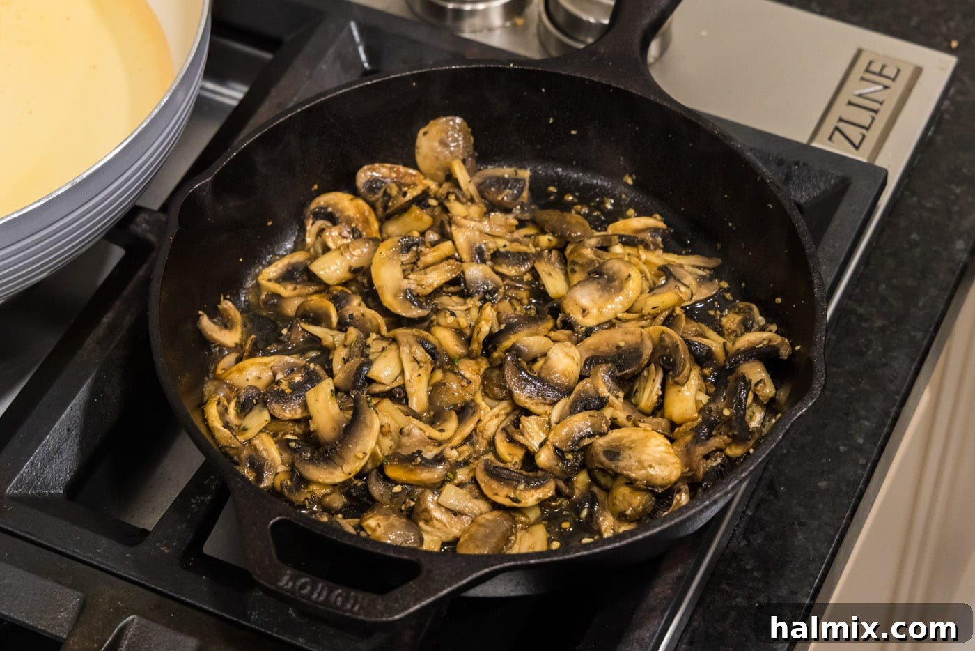 Close-up of easy sauteed mushrooms, glistening and perfectly browned, in a skillet.