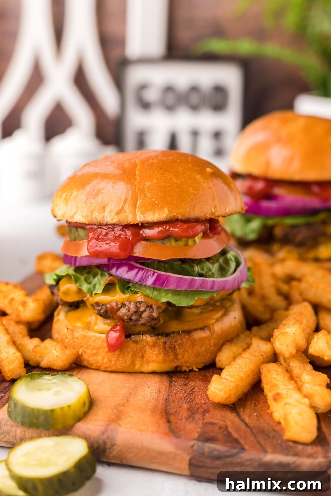 Smash Burger on a platter with pickles and french fries on the side, ready to be served