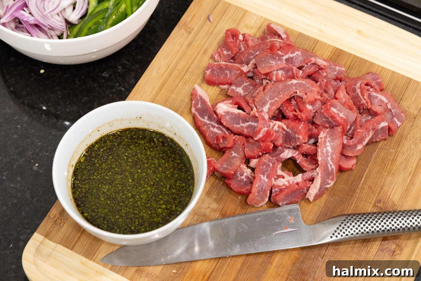 sliced flank steak with marinade on the side