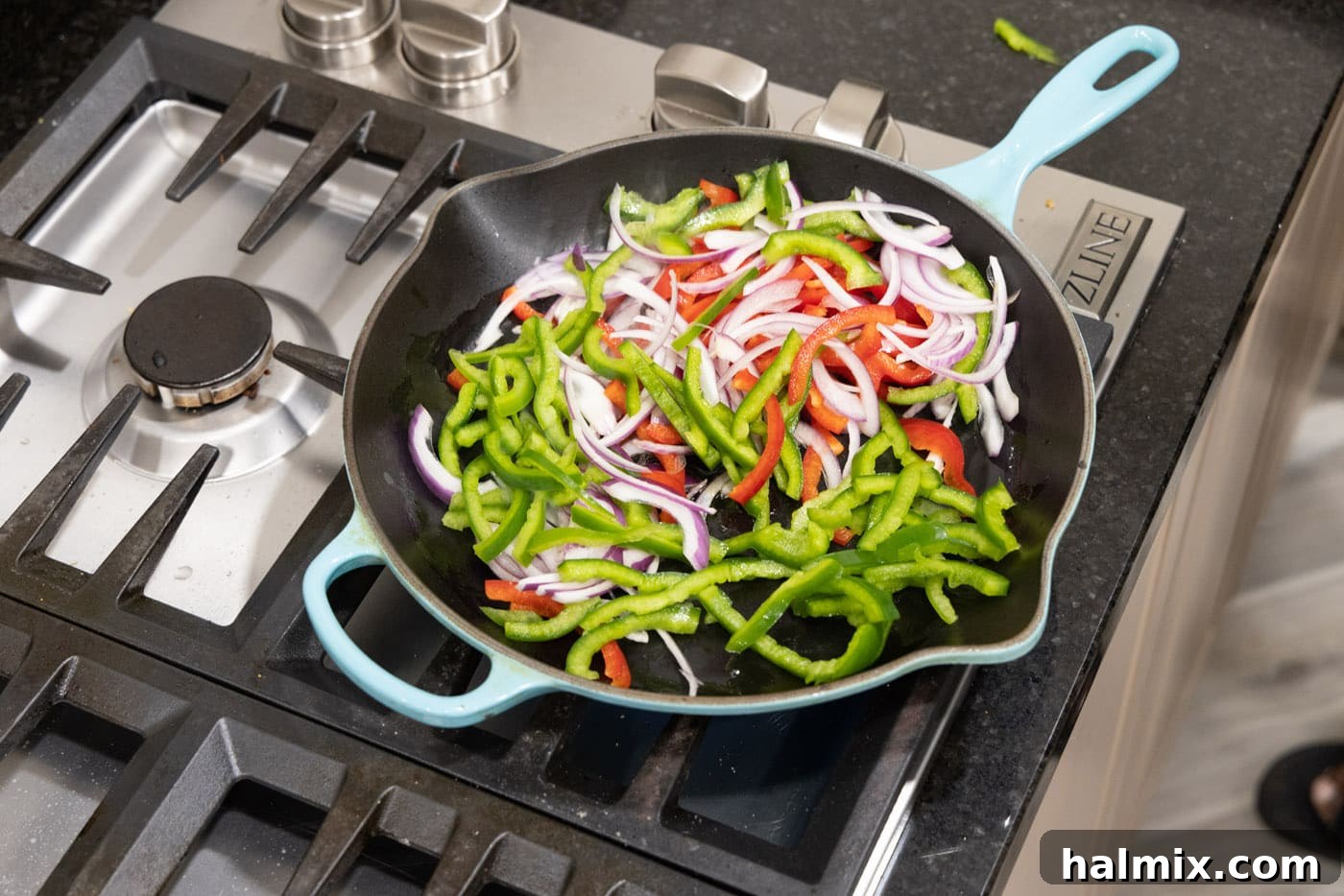 cooking bell peppers and onions in a skillet with oil