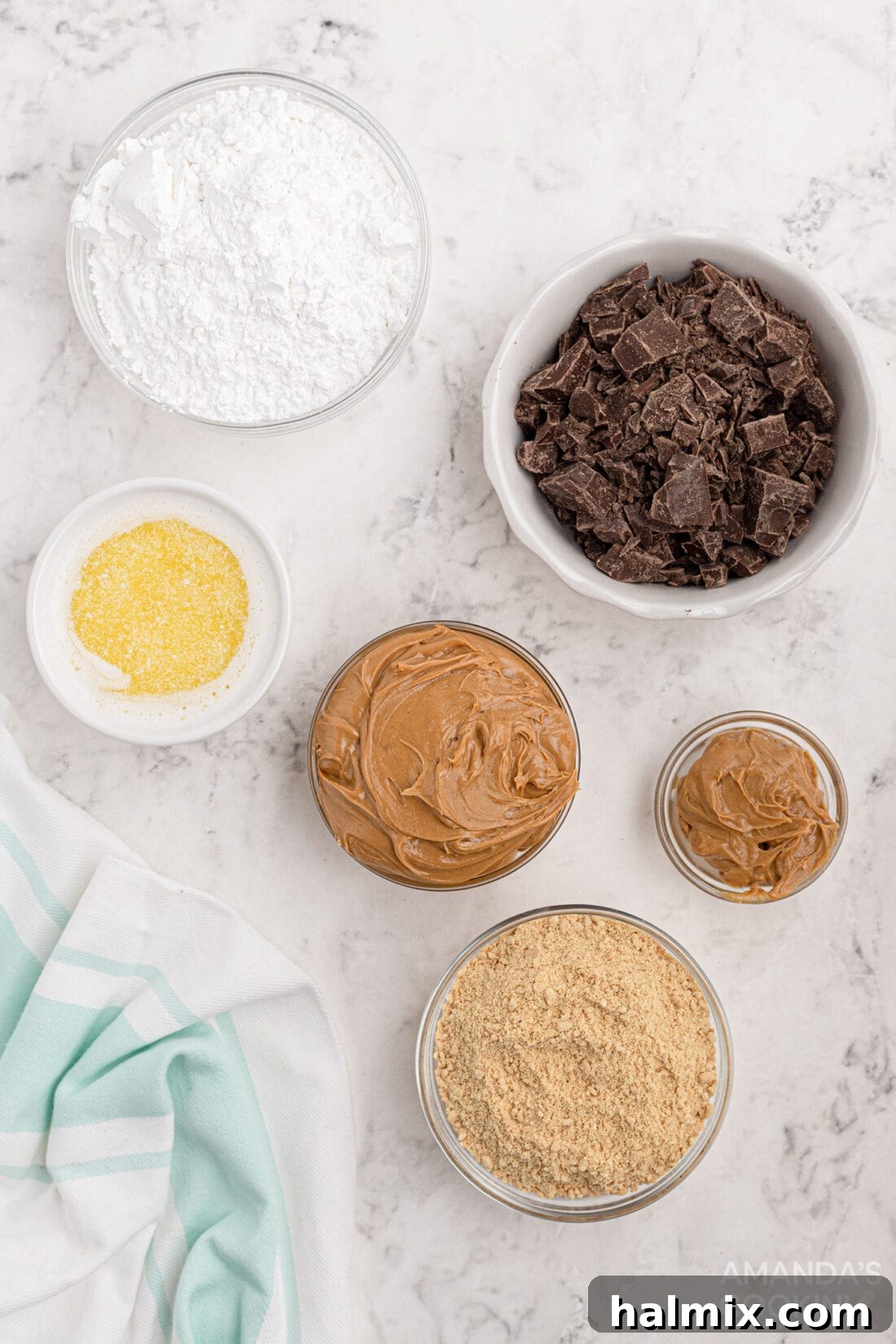 A flat lay photograph displaying all the ingredients for no-bake peanut butter bars, including butter, powdered sugar, peanut butter, and chocolate.