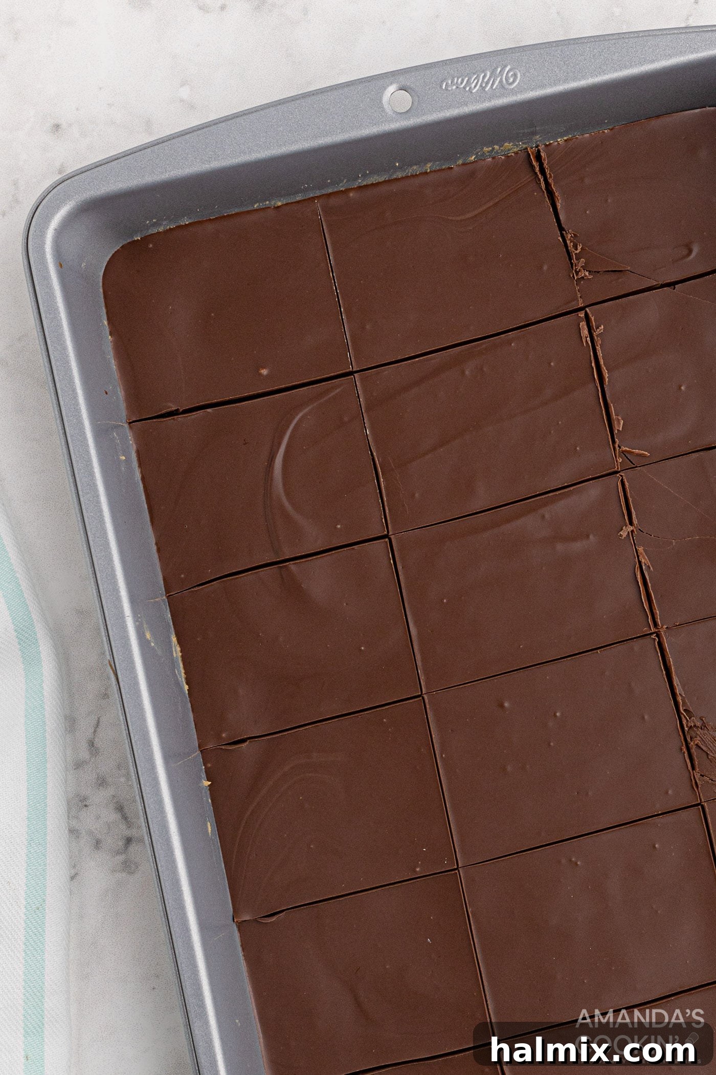 Chilled no-bake peanut butter bars, still in the baking pan, perfectly set and ready to be cut into individual servings.