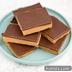 A stack of golden no-bake peanut butter bars topped with chocolate.