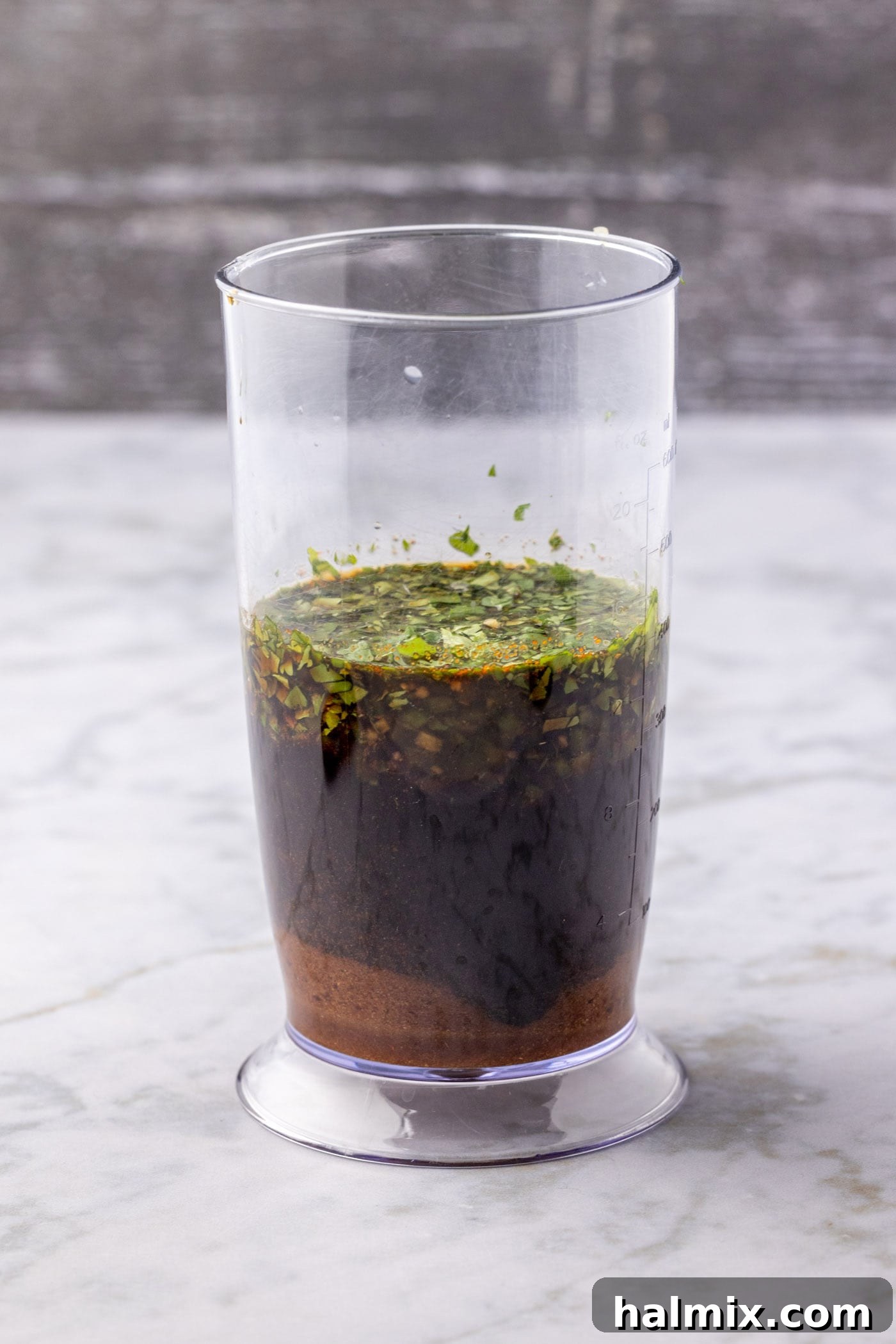 Fajita marinade ingredients being blended in an immersion blender for a smooth consistency