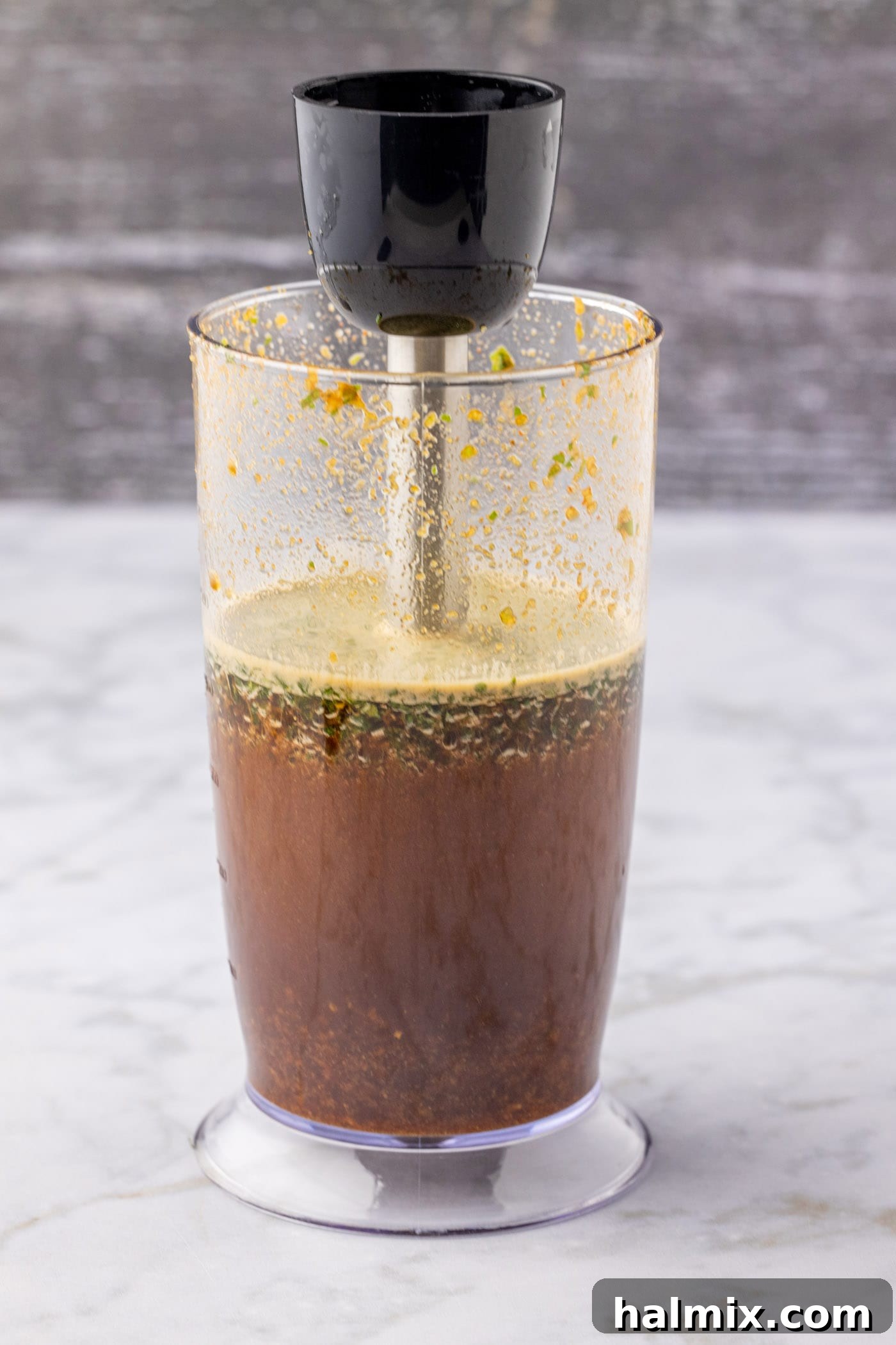 The process of blitzing marinade ingredients with an immersion blender for perfect mixing