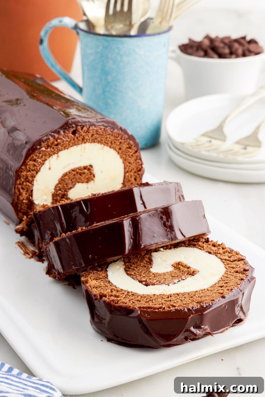 Decadent Chocolate Swirl Cake 2 Swiss Roll cut into slices on a platter, showcasing the beautiful chocolate swirl and white buttercream