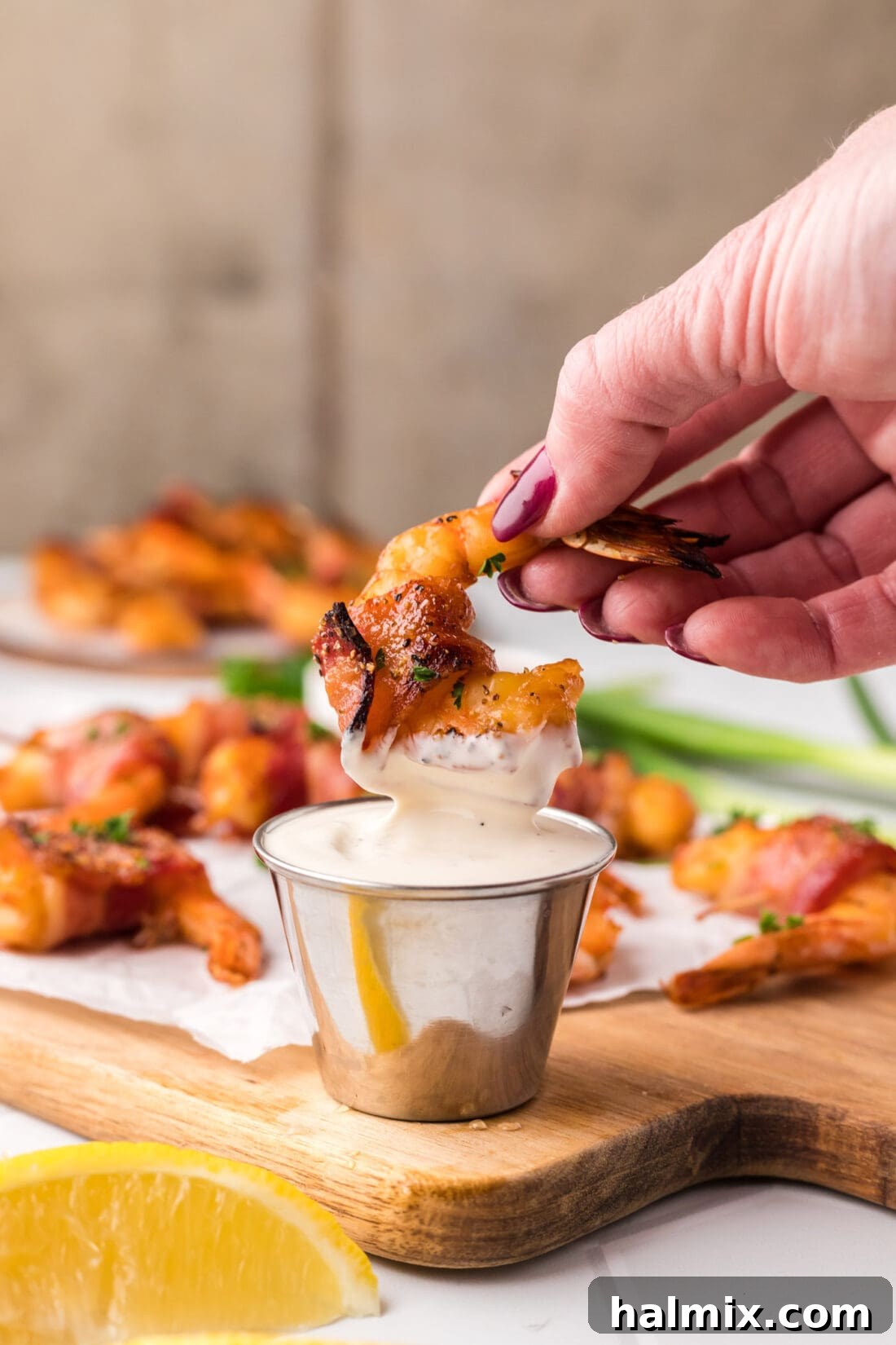The Ultimate Surf and Turf Appetizer 2 Bacon Wrapped Shrimp being dipped in ranch