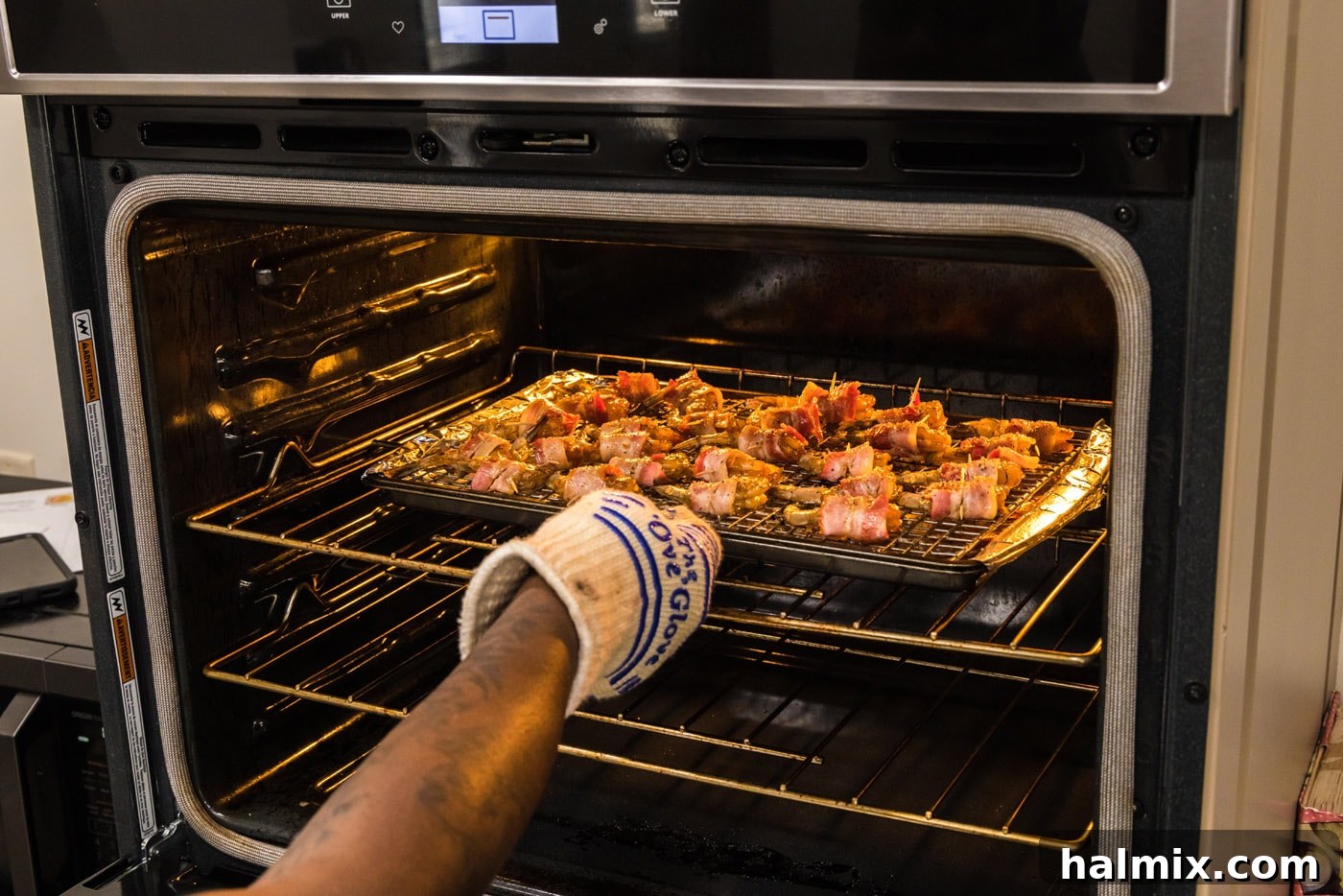 The Ultimate Surf and Turf Appetizer 15 placing bacon wrapped shrimp into the oven