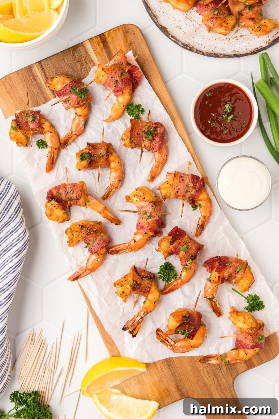 The Ultimate Surf and Turf Appetizer 3 Bacon Wrapped Shrimp on a wooden platter with parchment paper