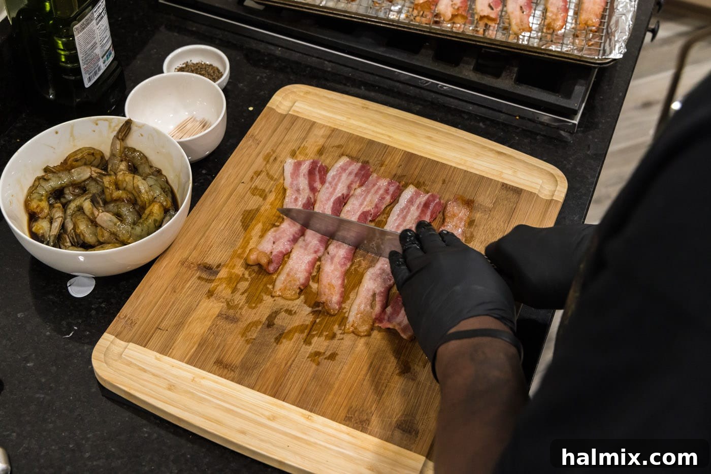 The Ultimate Surf and Turf Appetizer 10 slicing bacon in half on a cutting board