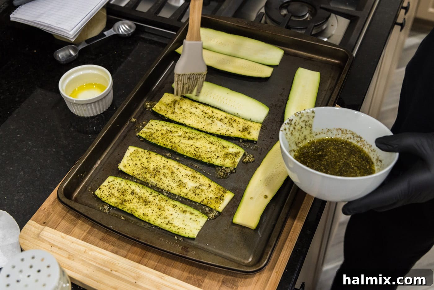 brushing oil and seasonings onto sliced zucchini