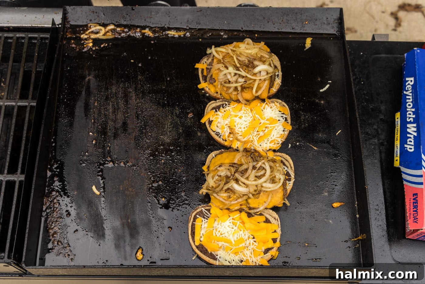 onions on top of burger and rye bread on a grill