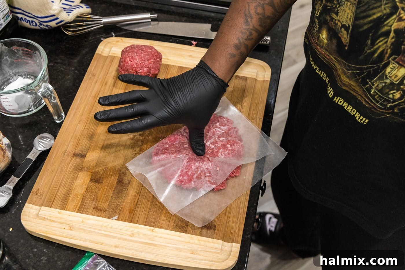 thumb pressing into burger patty to create an indent