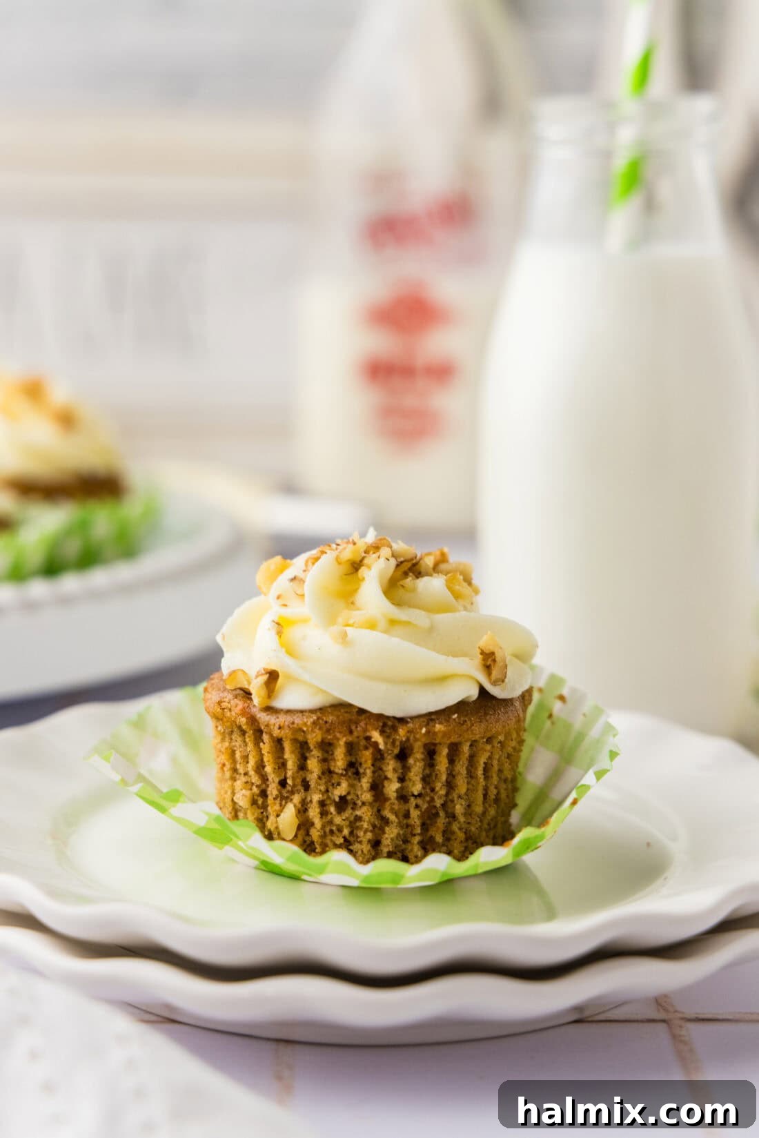 Decadent Carrot Cupcakes 2 Unwrapped Carrot Cupcake on a plate with milk in the background