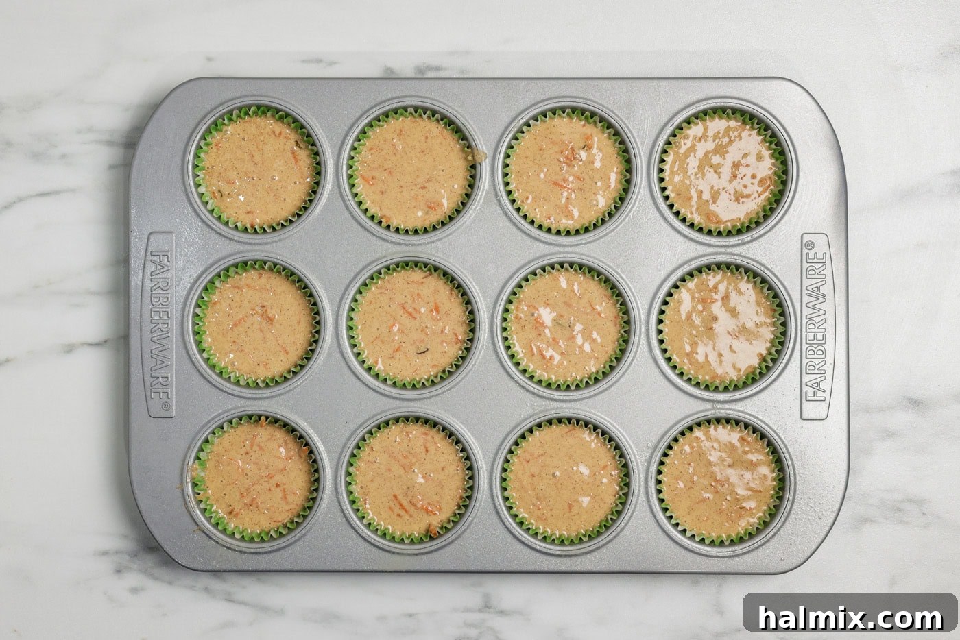 Decadent Carrot Cupcakes 8 carrot cupcake batter in a muffin tray lined with paper cupcakes liners