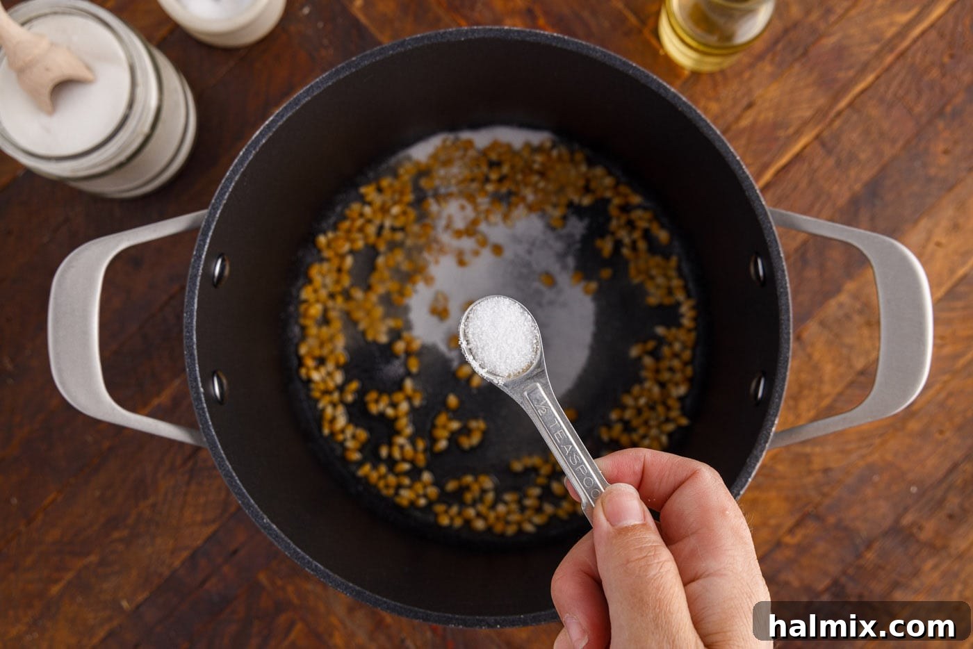 Adding sea salt to the sugar-coated corn kernels