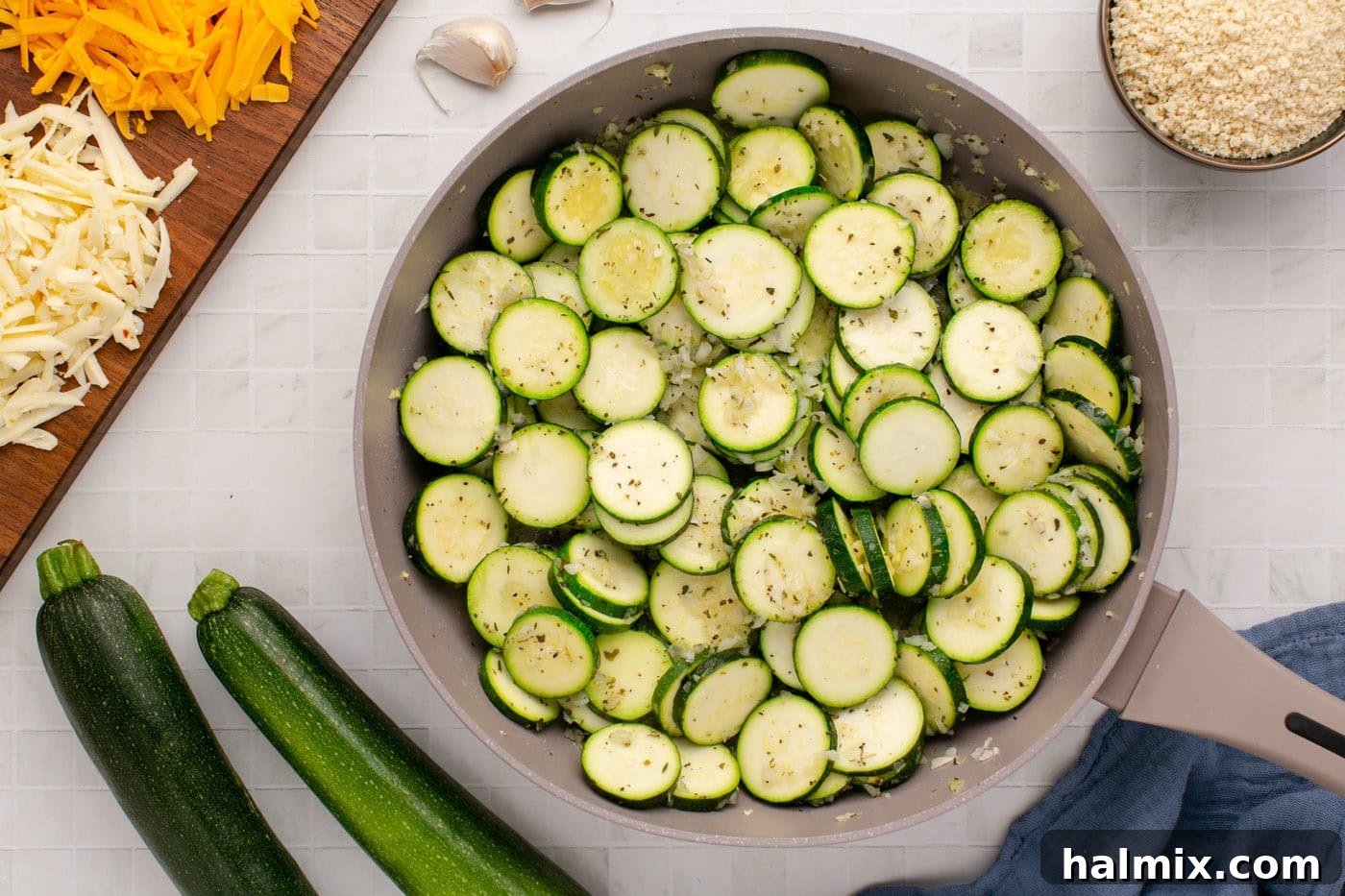 Close-up view of sliced zucchini rounds gently cooking in a skillet, softening and gaining a slight golden hue.