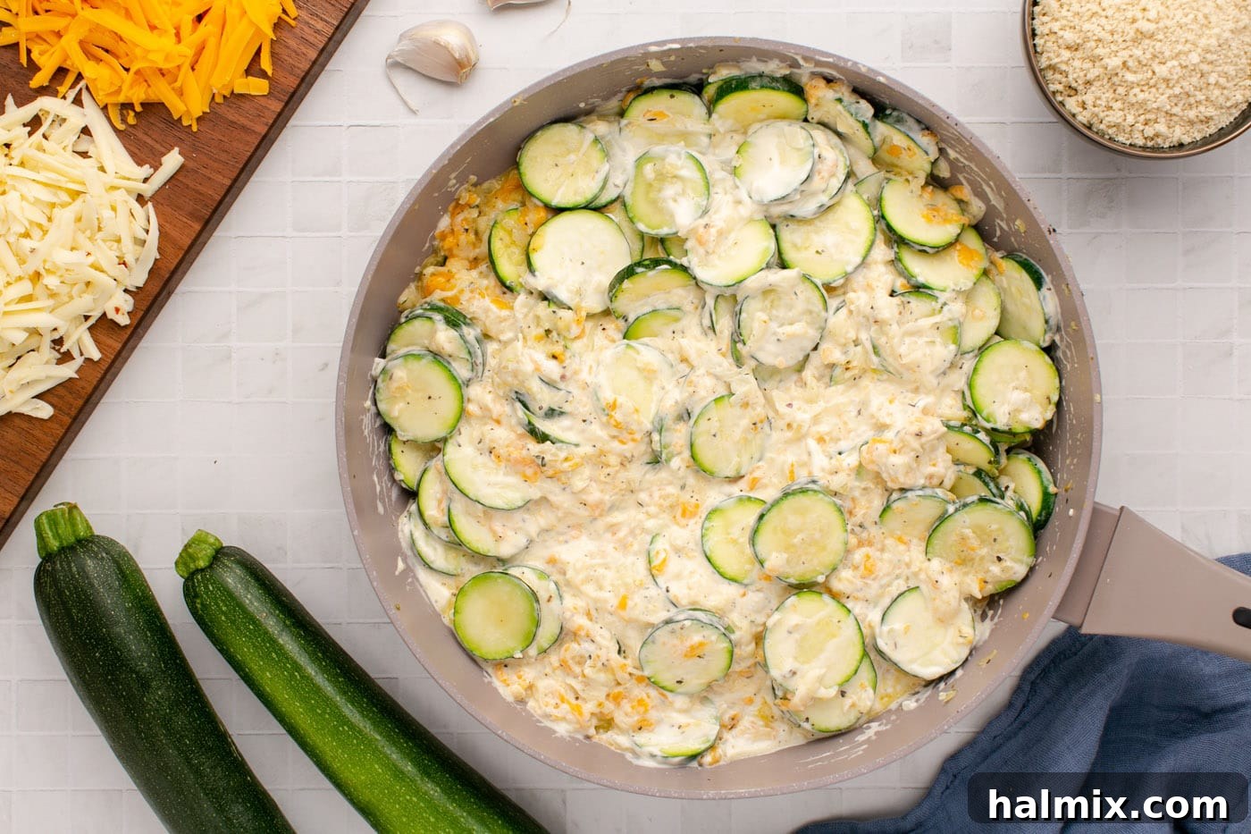 The fully combined cheesy zucchini mixture, rich and creamy, ready to be transferred from the skillet to the baking dish.