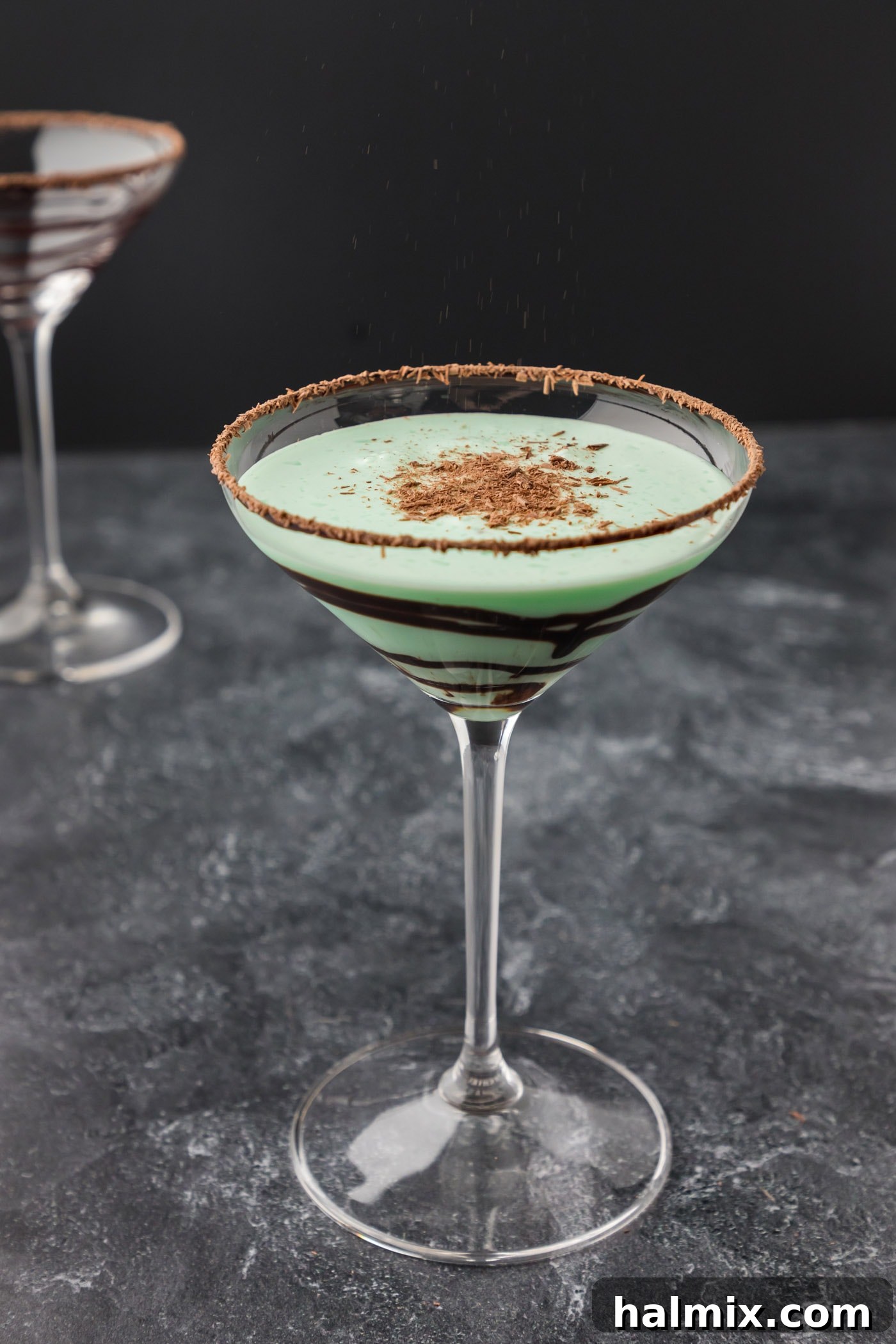 A freshly made Grasshopper cocktail garnished with a sprinkle of shaved chocolate on top, ready to be enjoyed.