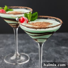 Two Grasshopper Drinks garnished with a cherry and mint sprig