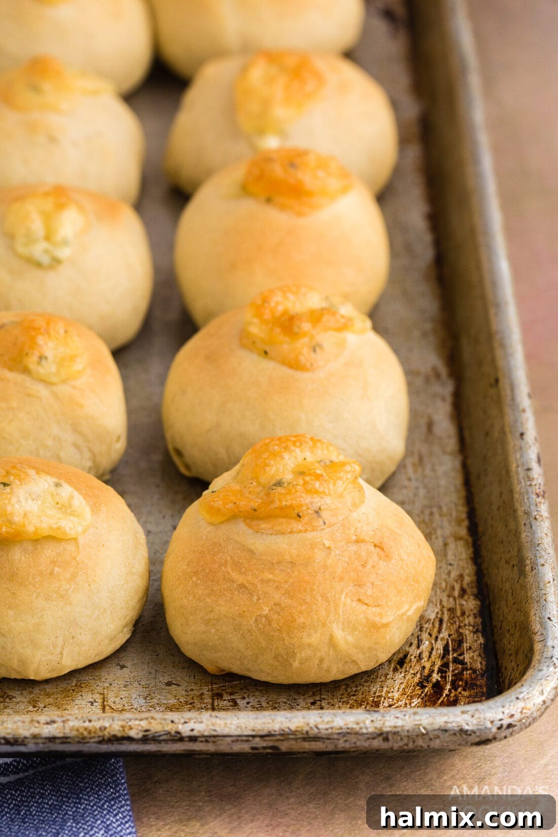 A baking pan filled with freshly baked garlic cheese rolls, glistening with melted butter.