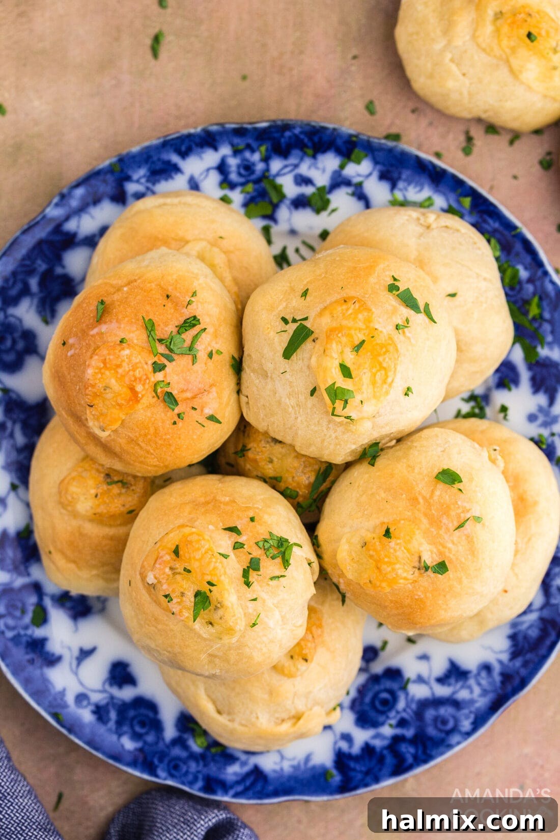 A white plate with several garlic cheese rolls, garnished with fresh parsley.