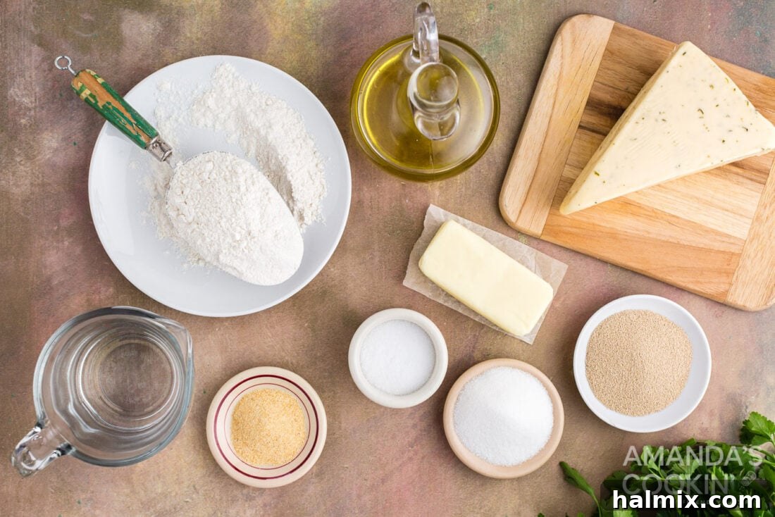 A flat lay of ingredients for garlic cheese rolls, including flour, cheese, yeast, and butter.
