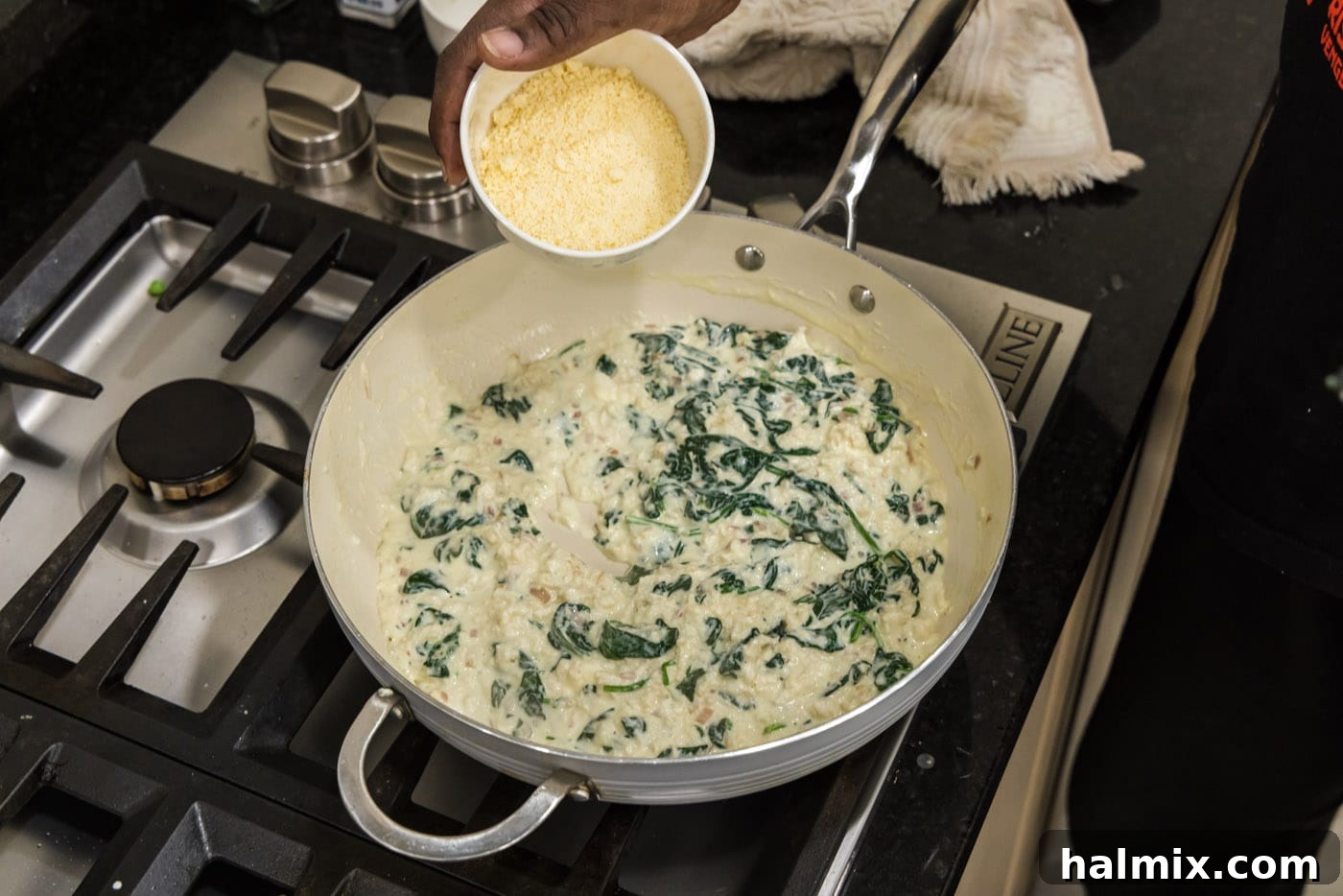 Adding grated Parmesan cheese to the simmering salmon stuffing mixture in the skillet to thicken and enhance flavor.