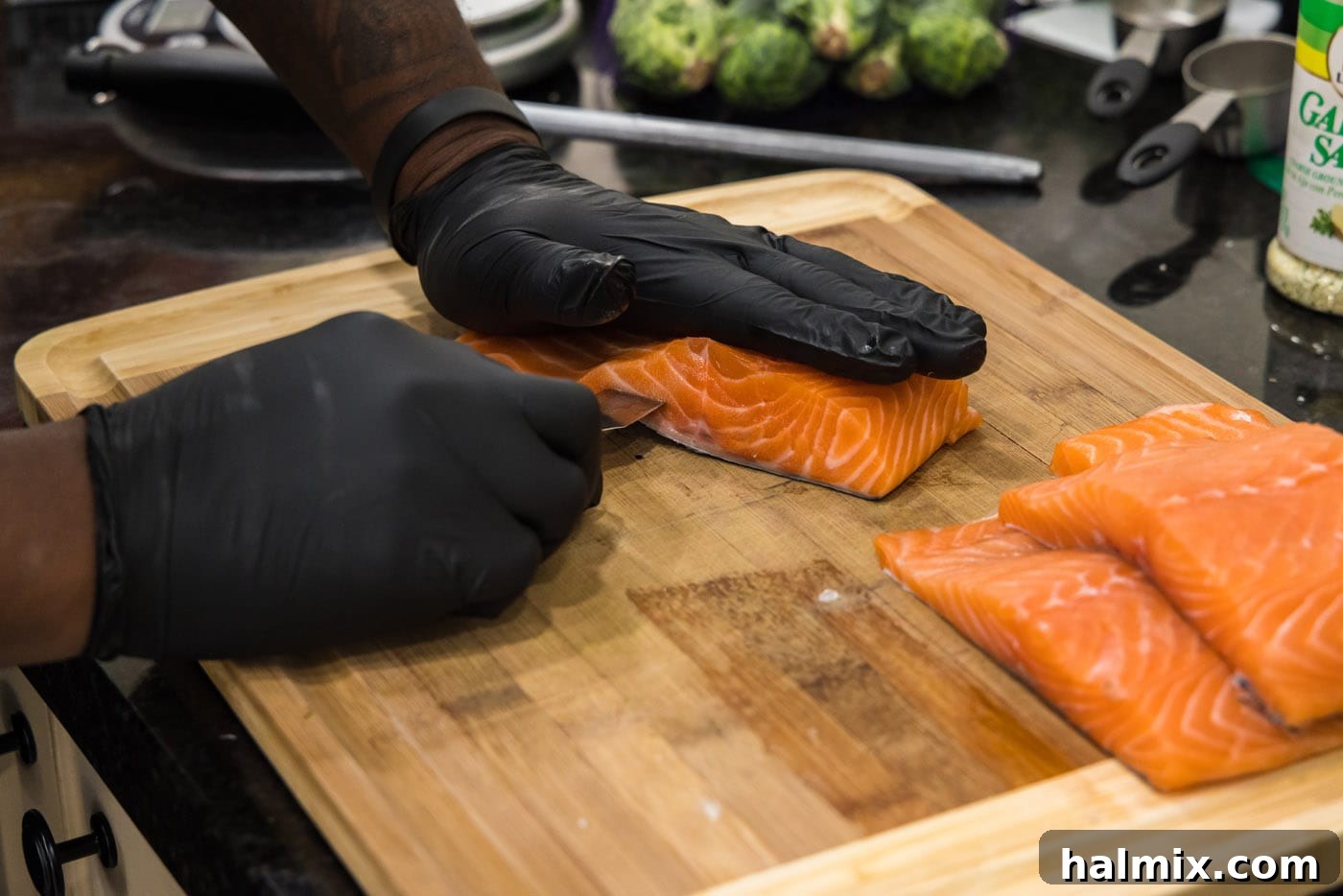 Carefully slicing into a salmon fillet with a paring knife to create a pocket for the stuffing.