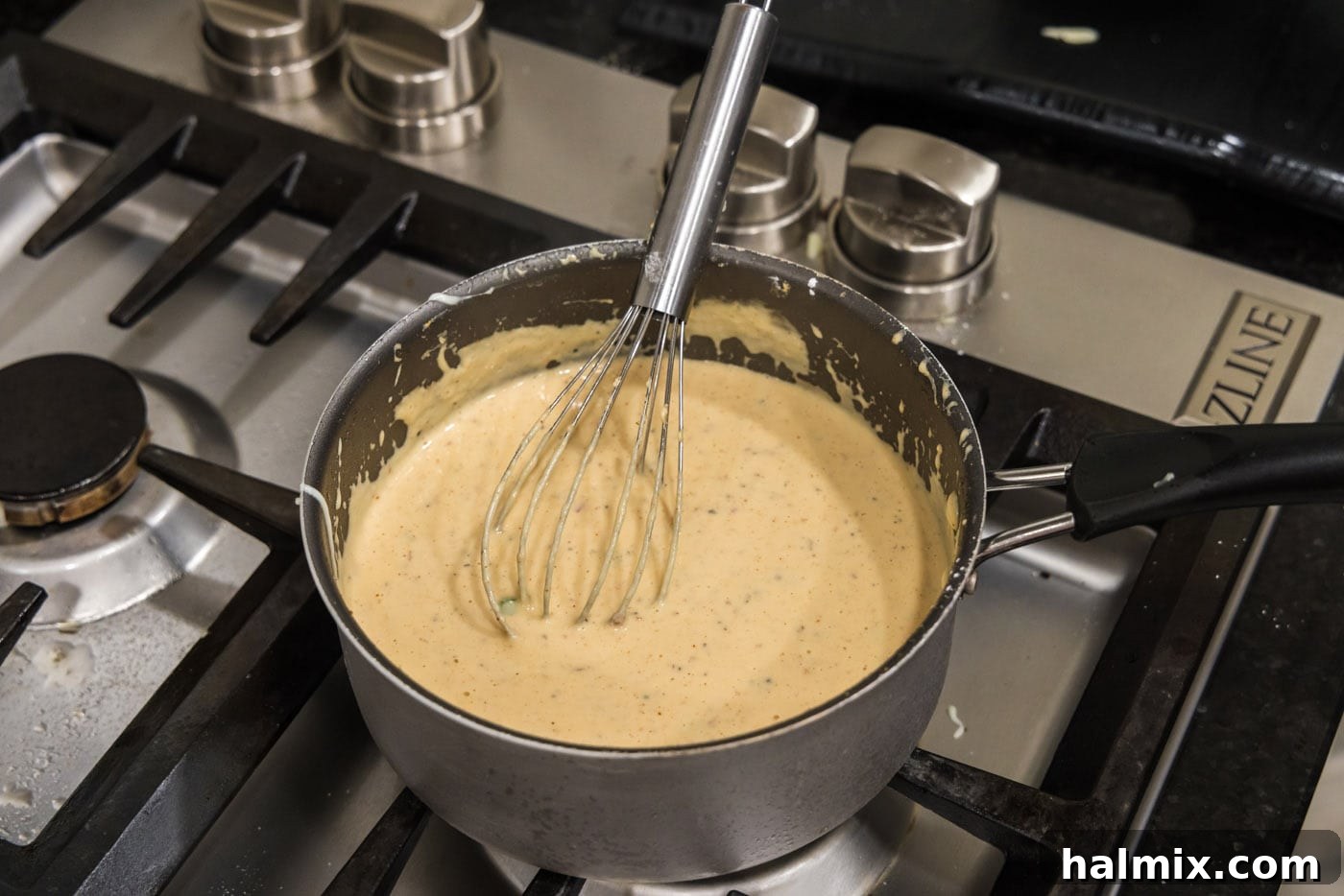 whisking queso dip in a saucepan