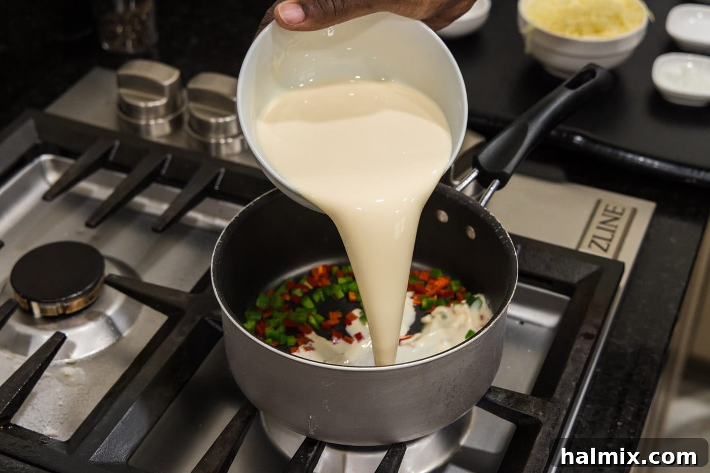 pouring evaporated milk into saucepan with peppers