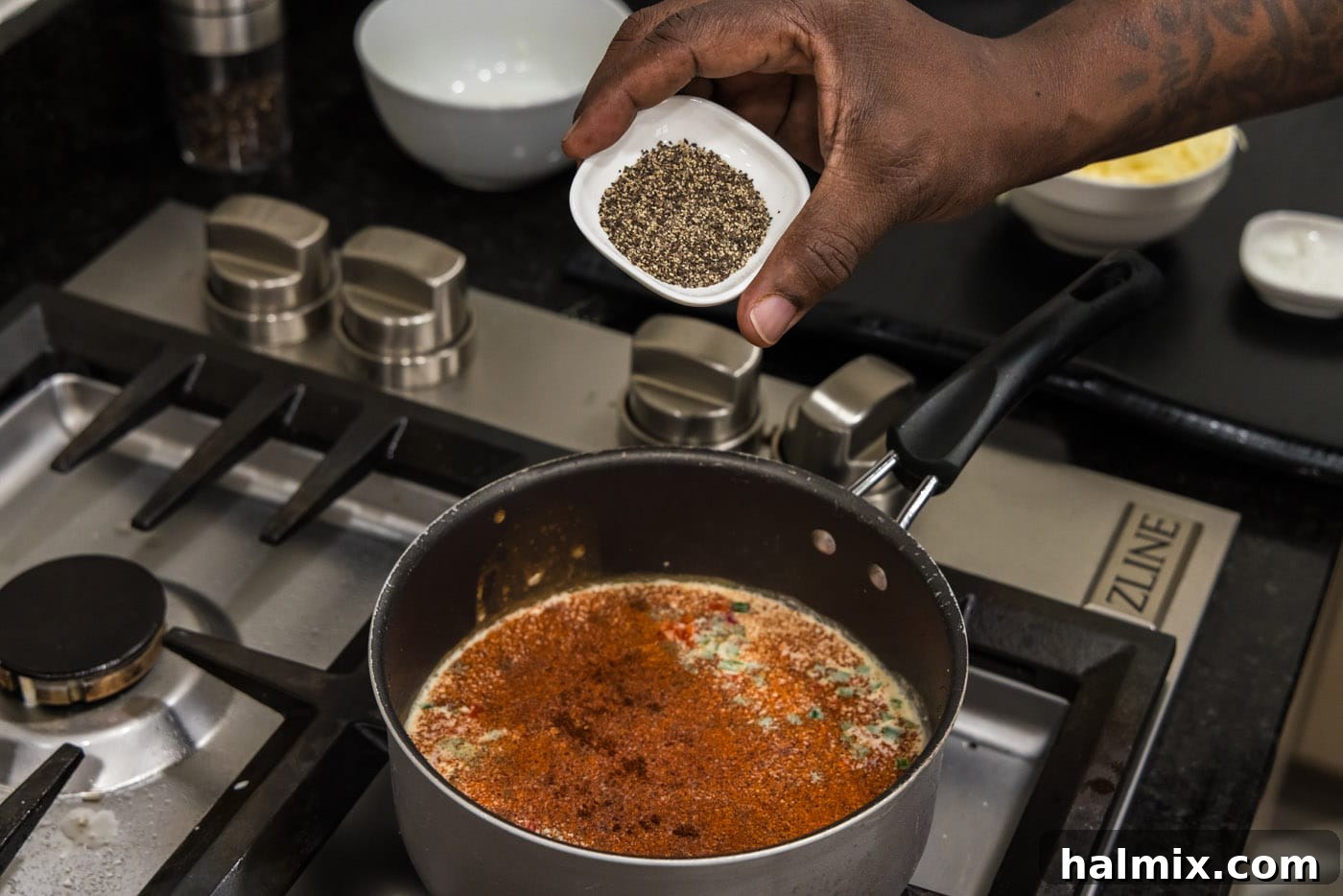 adding spices to queso dip in saucepan