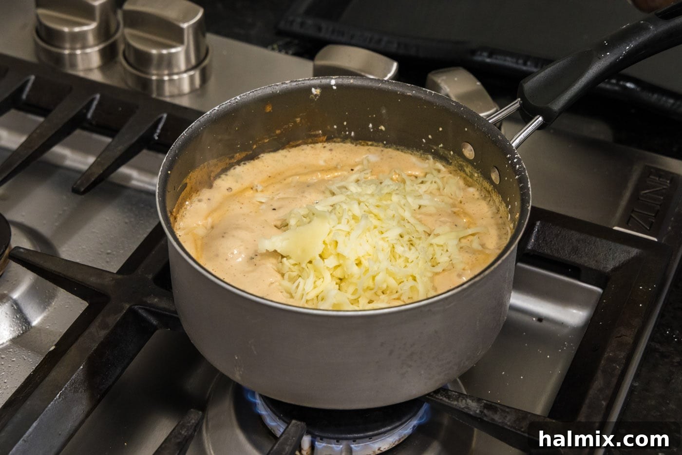 mozzarella and white cheddar added to saucepan with sauce mixture