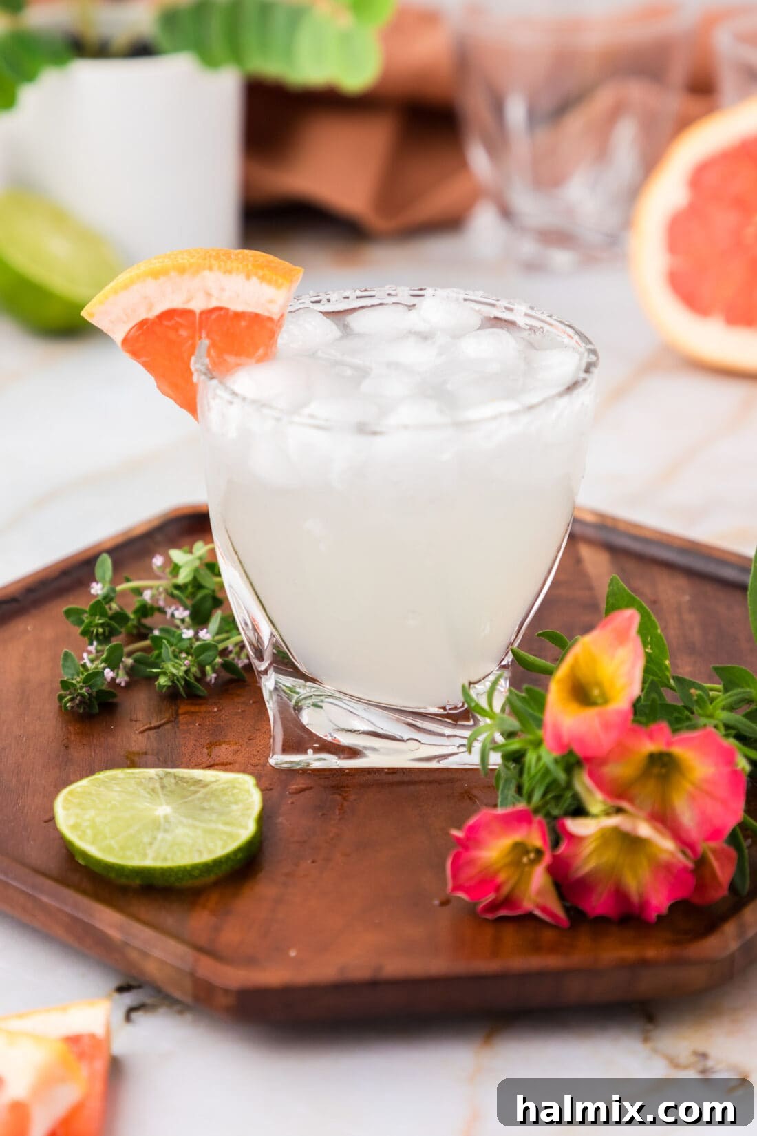 Paloma on a wooden tray with flowers and a lime wheel