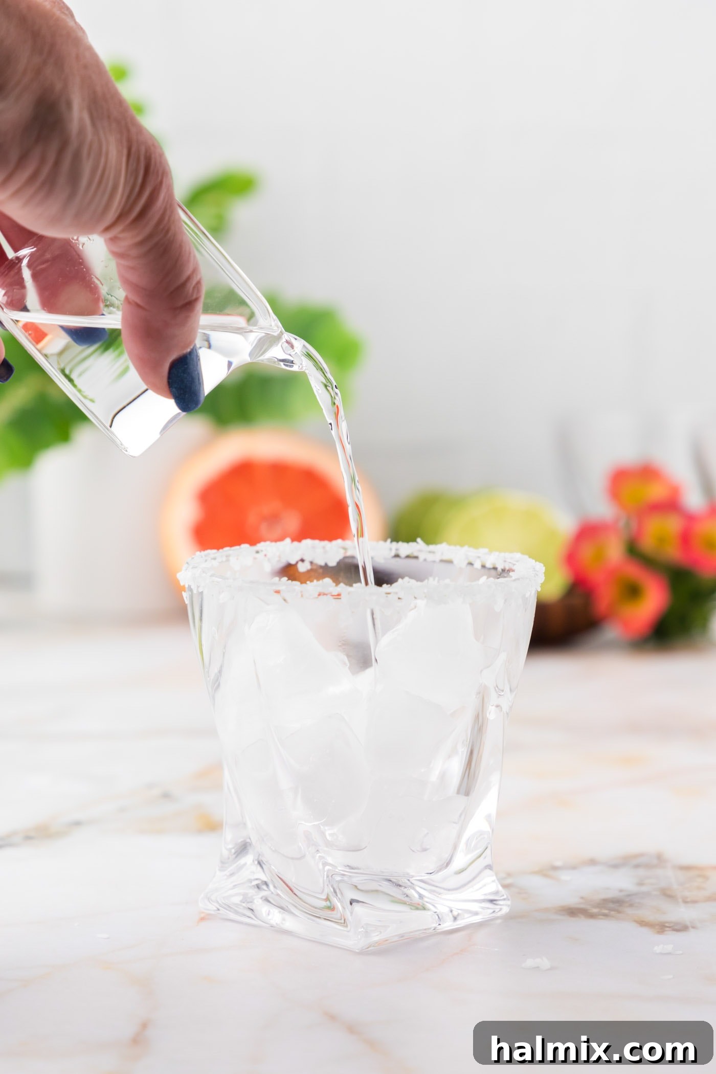 pouring tequila into rock glass