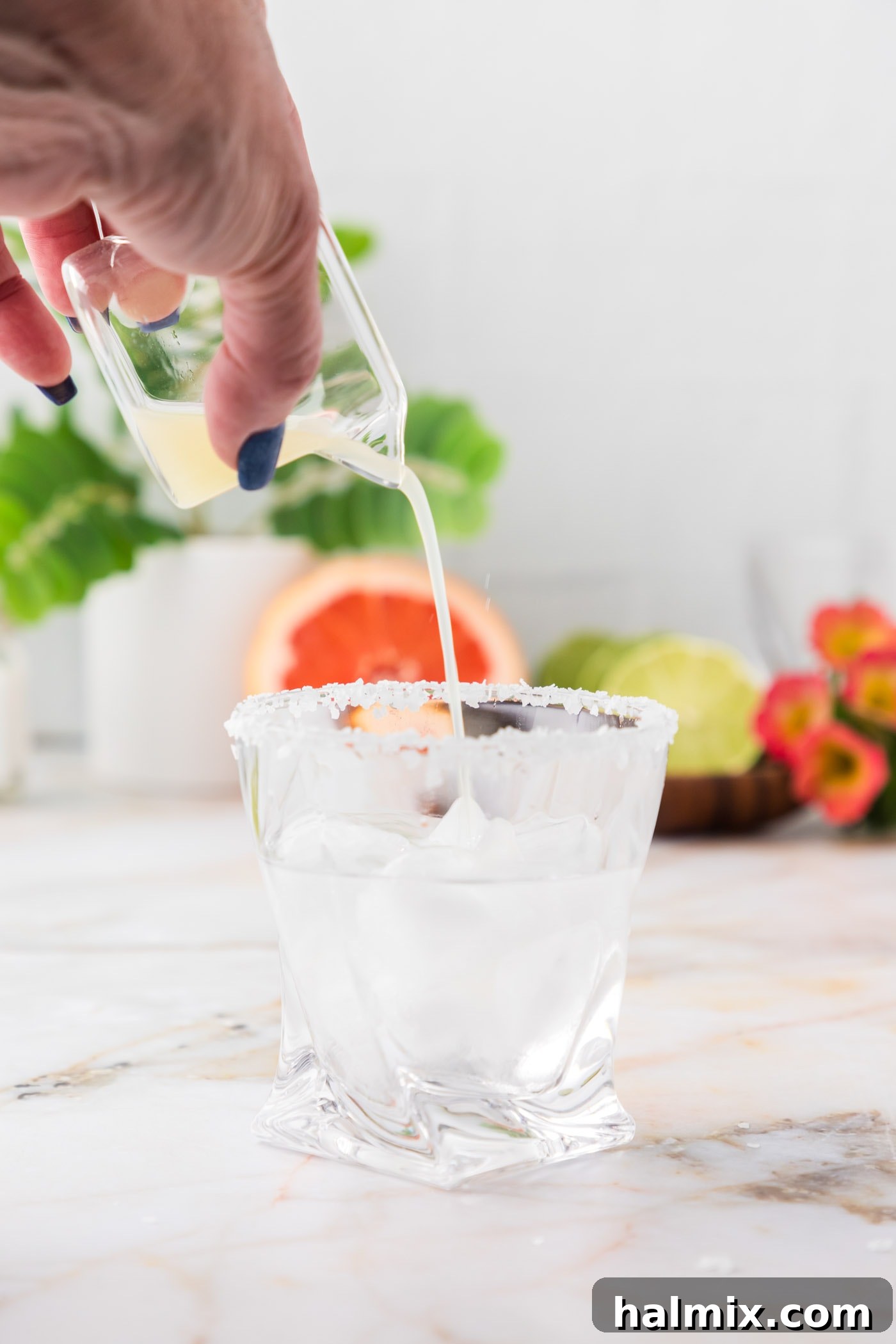 pouring lime juice over blanco tequila