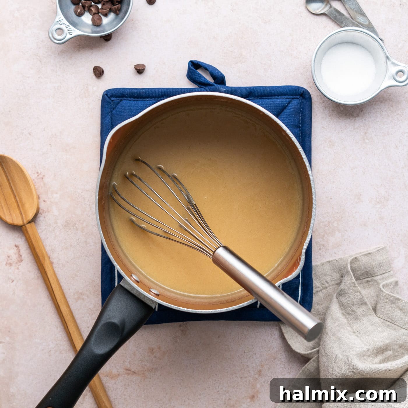 whisking homemade caramel in a saucepan