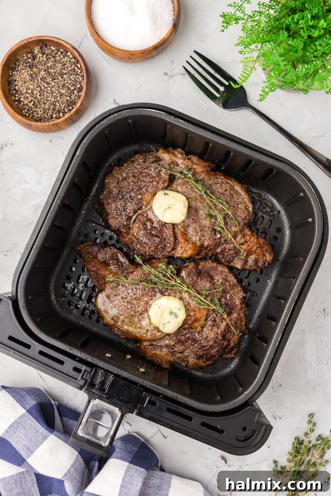 Two cooked steaks in an Air Fryer, perfectly seared and ready to eat.