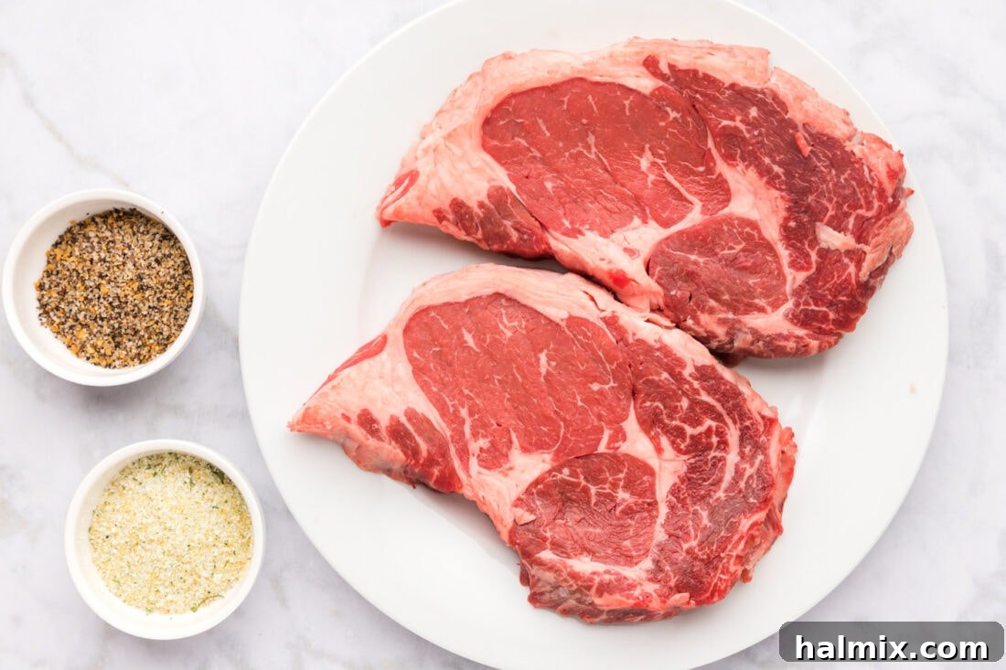 A collection of ingredients for making Air Fryer Steak, including raw beef, seasonings, and cooking spray.