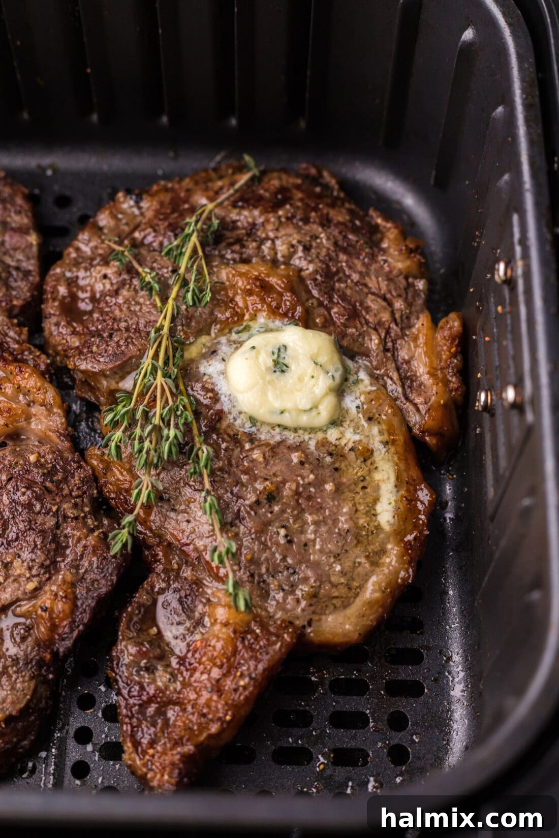 Close up photo of Air Fryer Steak in an air fryer, showcasing the beautiful sear and juicy texture.