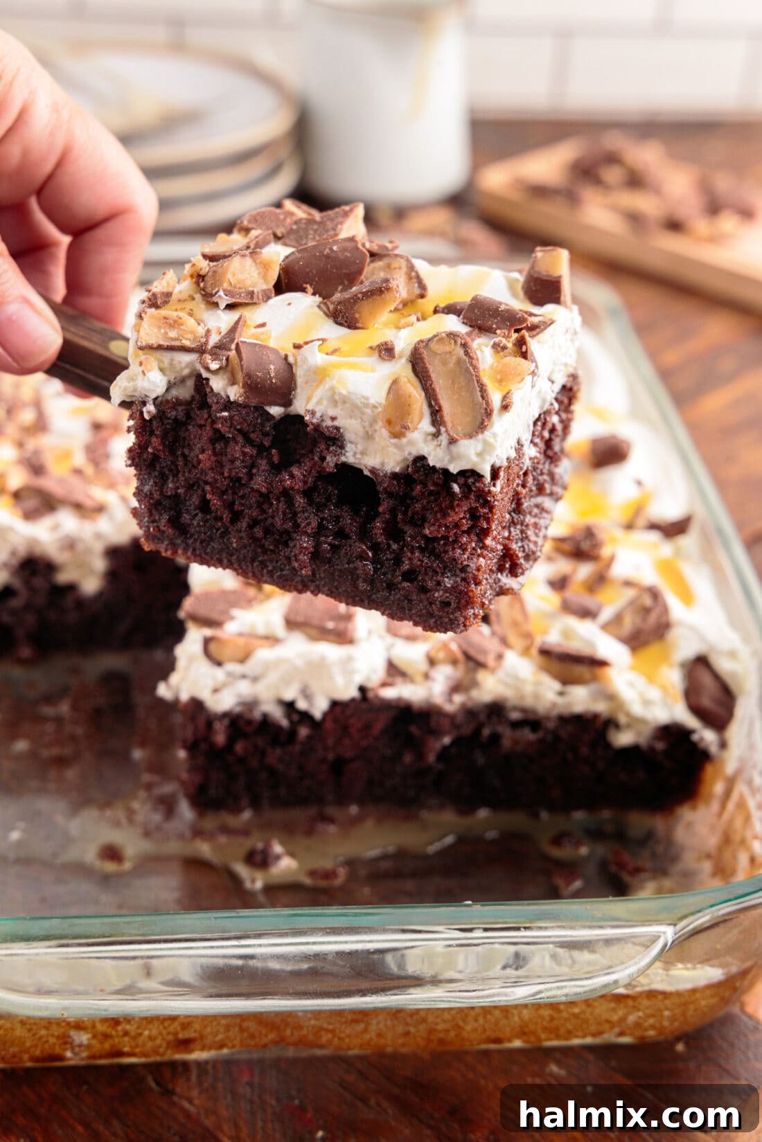 A glorious slice of Better Than Sex Cake being lifted from a baking pan, showcasing its rich, layered goodness and inviting caramel drizzle.