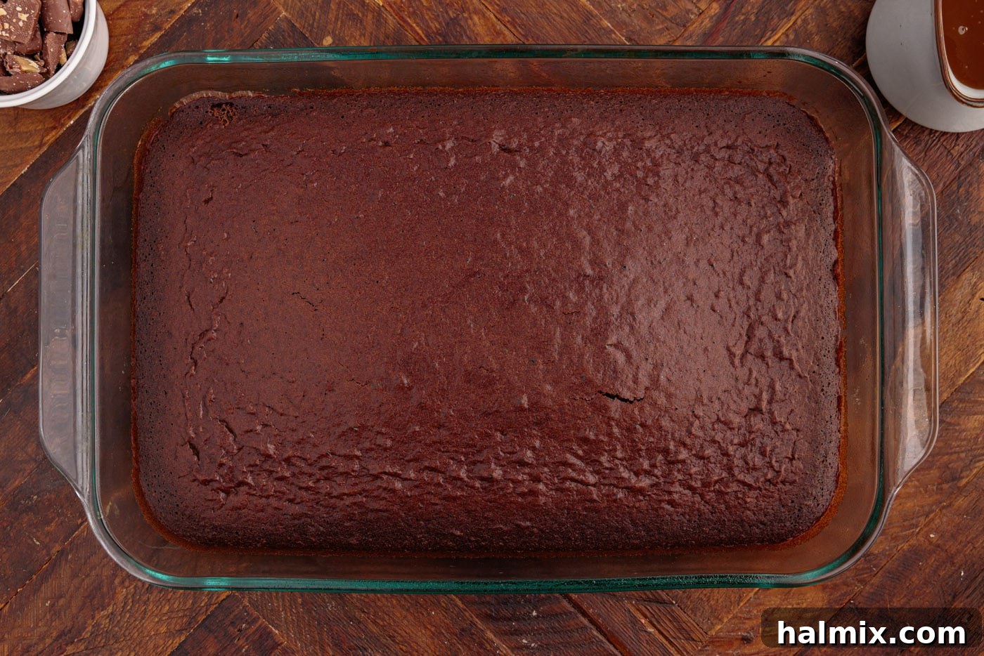 A freshly baked devil's food cake, golden brown and perfectly risen in a baking pan, cooling on a rack.
