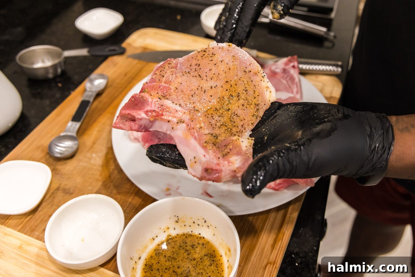 adding seasoning to pork chops