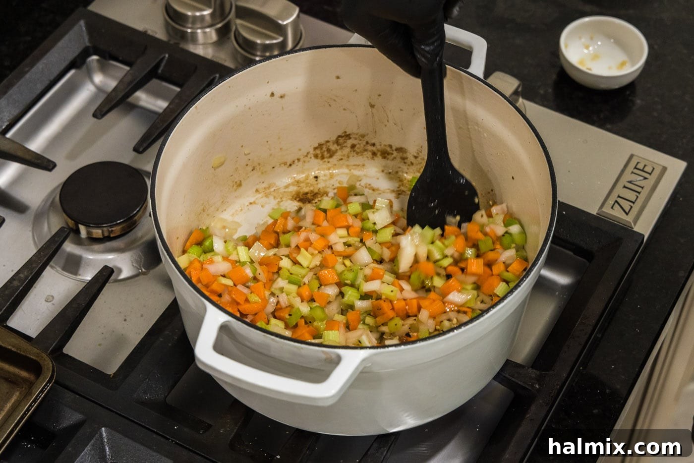 Stirring vegetables in a Dutch oven as they soften