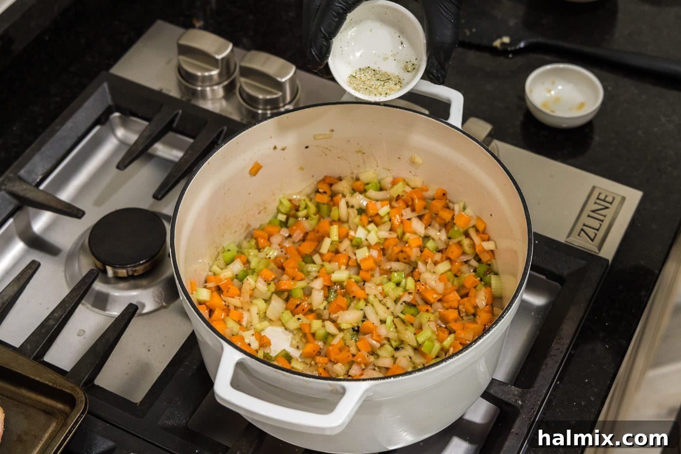 Seasoning vegetables with garlic salt in a Dutch oven