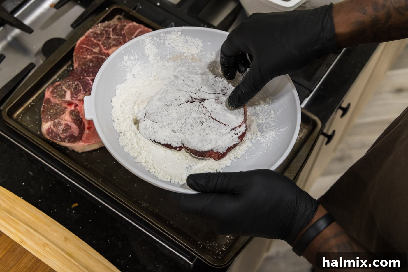 Dipping beef shanks in cornstarch for coating