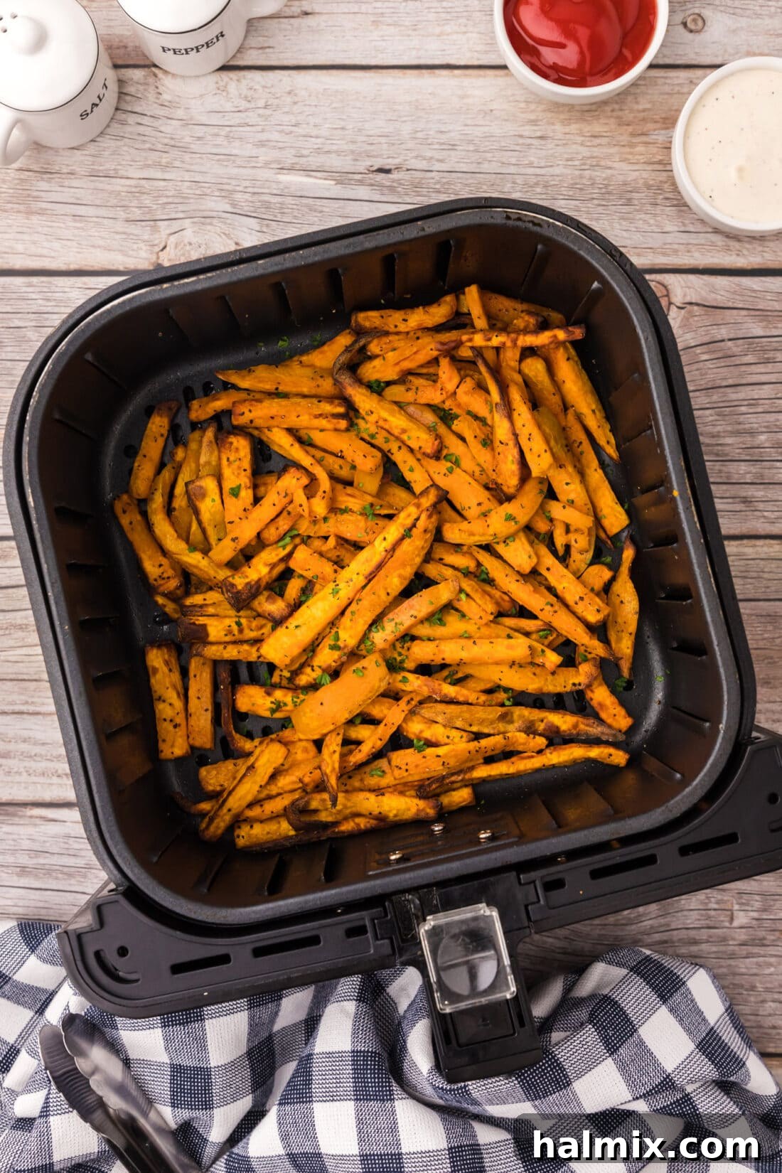 Air Fryer Sweet Potato Fries in an air fryer basket, perfectly golden and crispy.