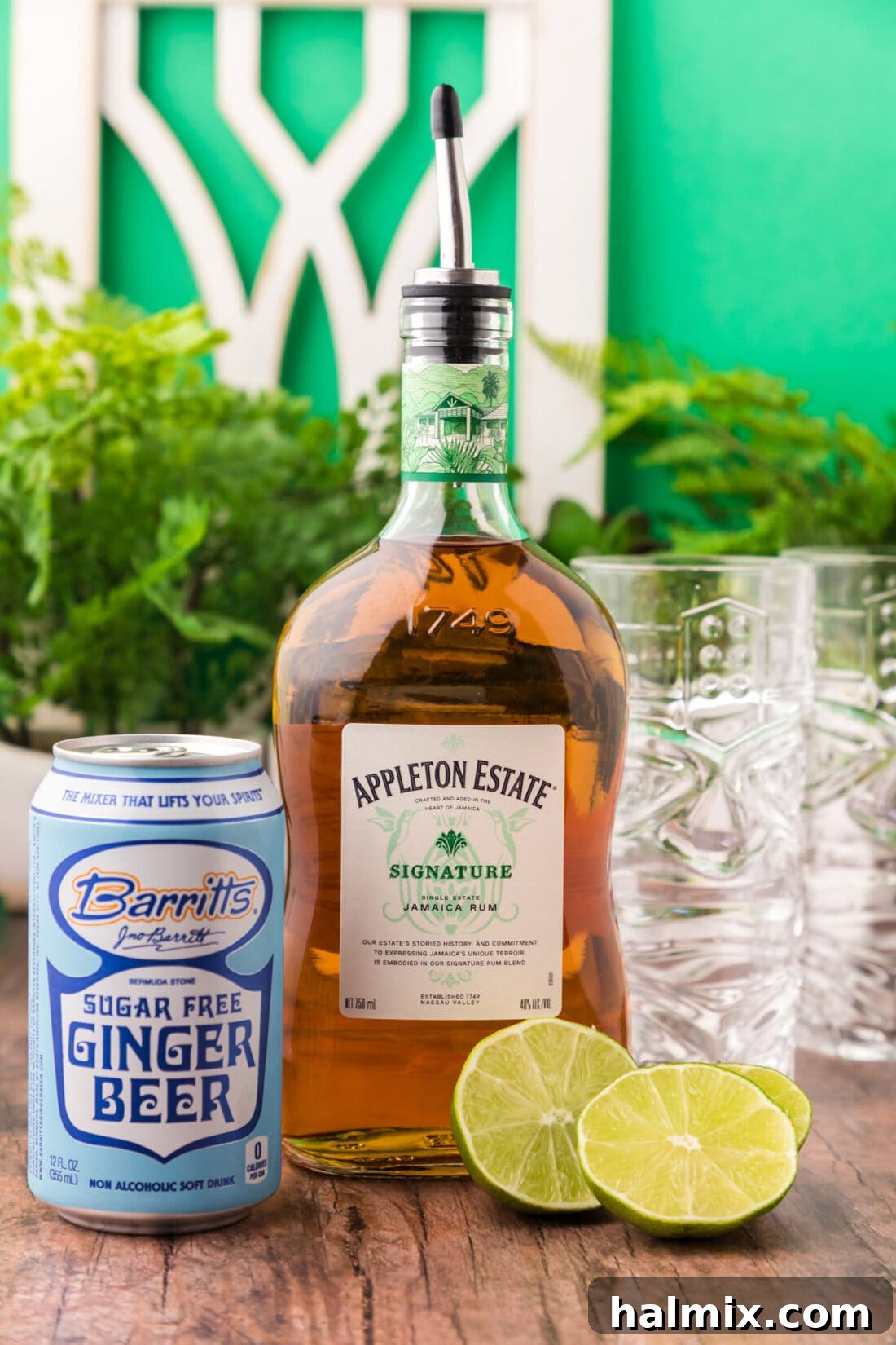 Fresh ingredients laid out for a Jamaican Mule: a bottle of Jamaican rum, fresh limes, and a bottle of ginger beer, ready for cocktail preparation.