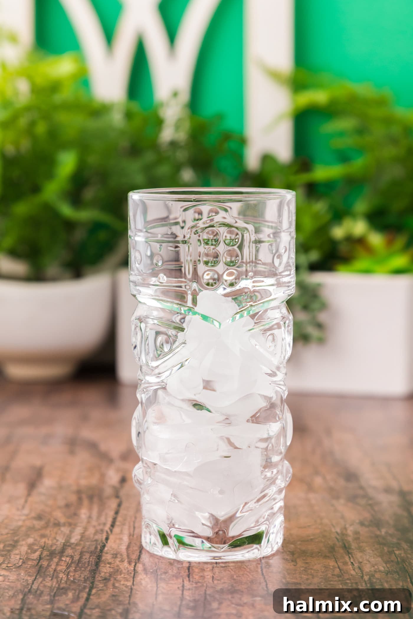 Tiki glass filled with ice cubes, ready for cocktail preparation.