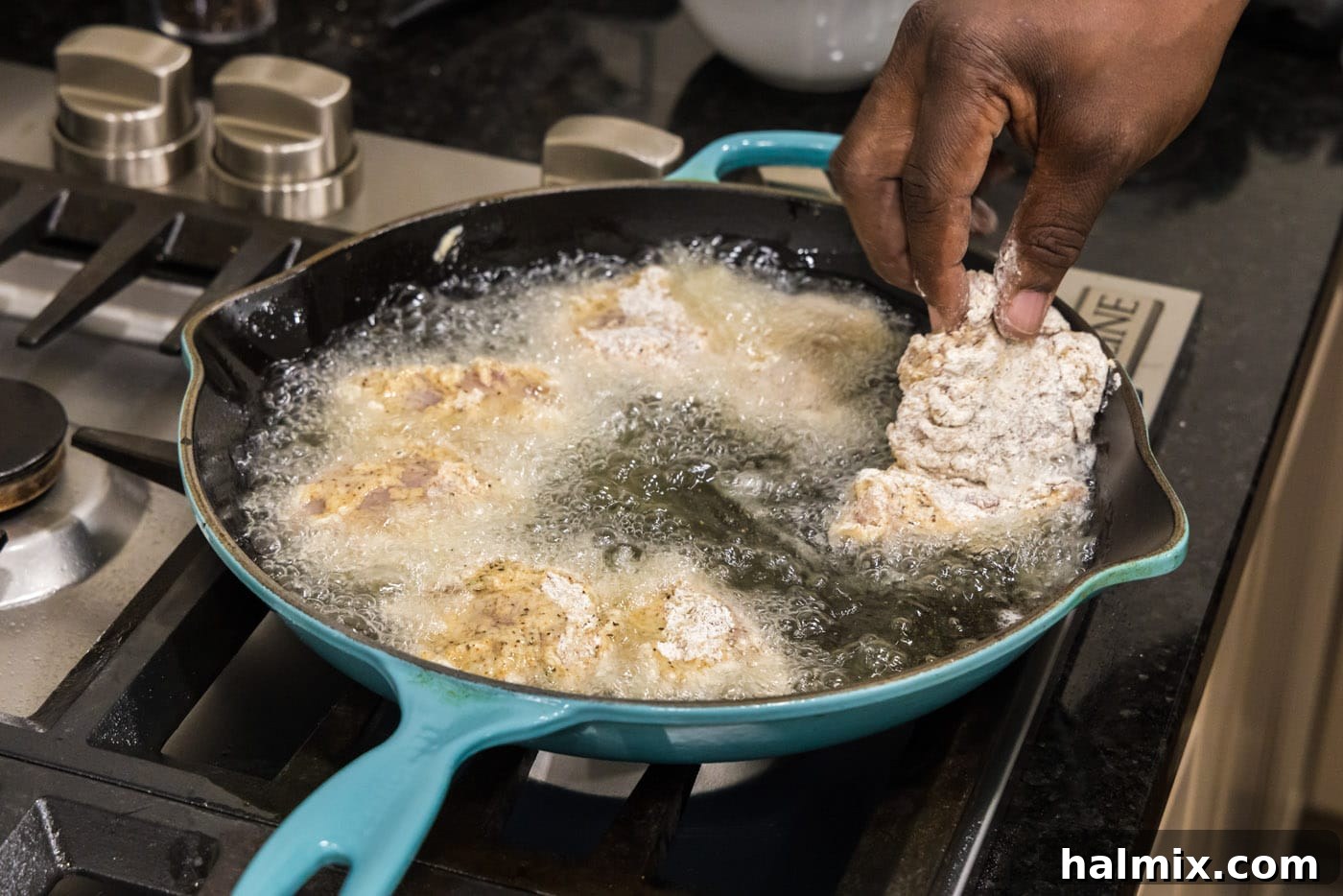 Southern Fried Bliss 12 Carefully adding dredged chicken thighs into hot frying oil